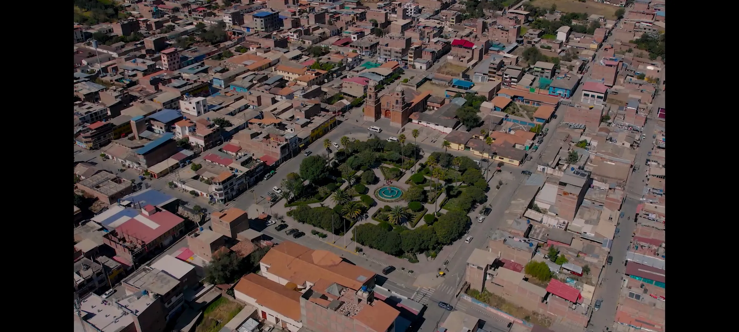 Pelotón de ciclistas ascendiendo por valle andino
