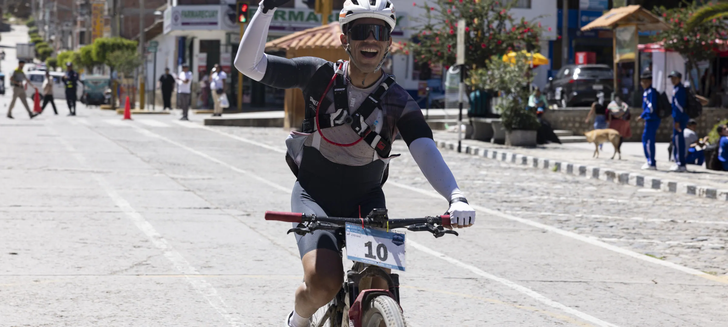 Ciclista cruzando la meta con los brazos arriba