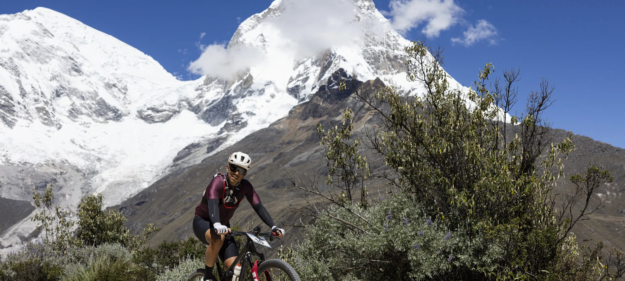 Ciclista con nevado imponente al fondo